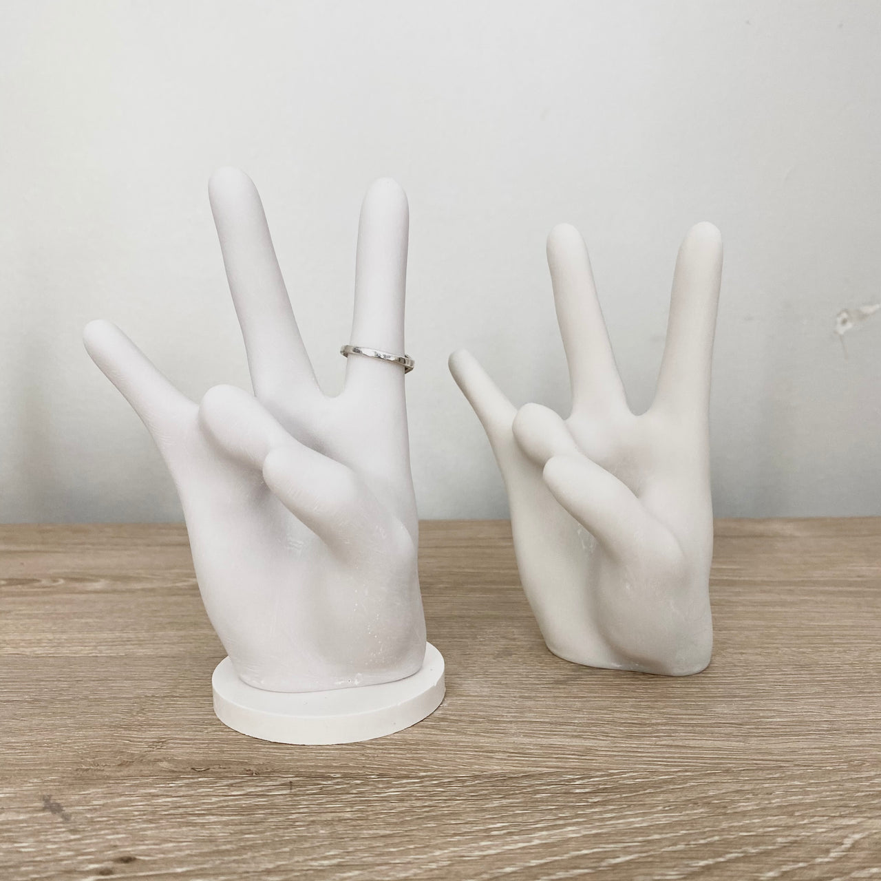 white bonded marble ring holder in shape of cougar hand signal on desk