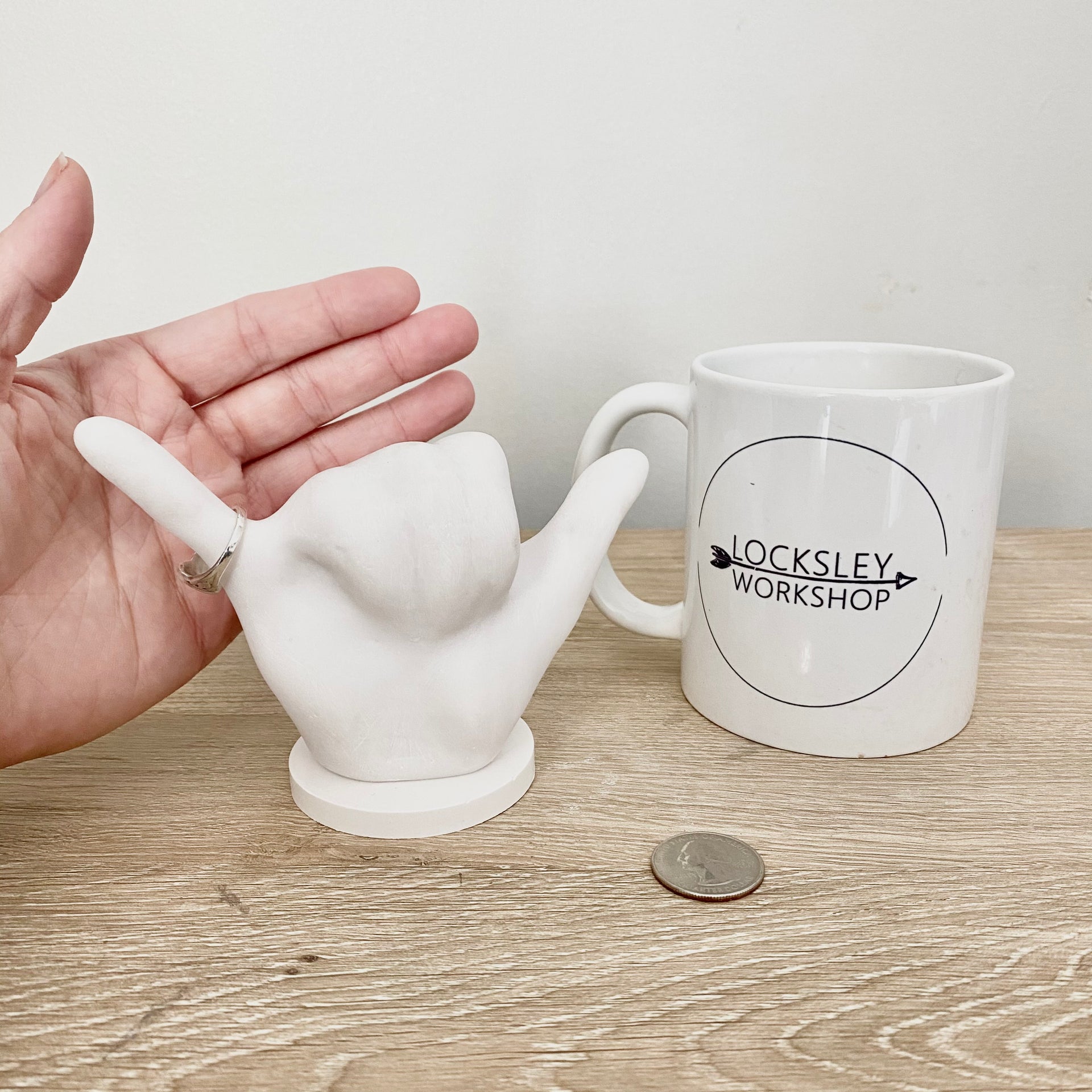 Size comparison for ring holder. Hand, mug, and quarter included for reference.