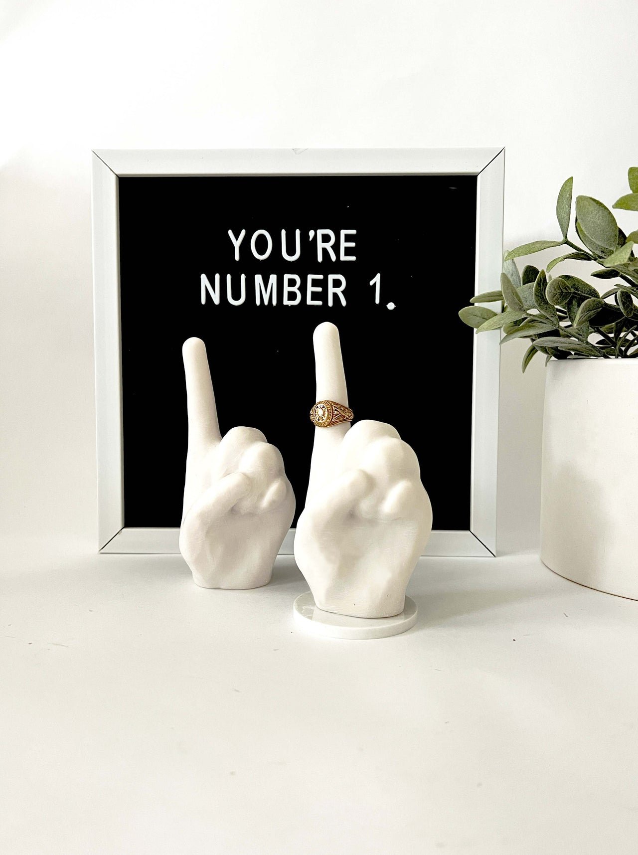 Two ring holders signaling number one. Bonded marble with one situated on a base.t