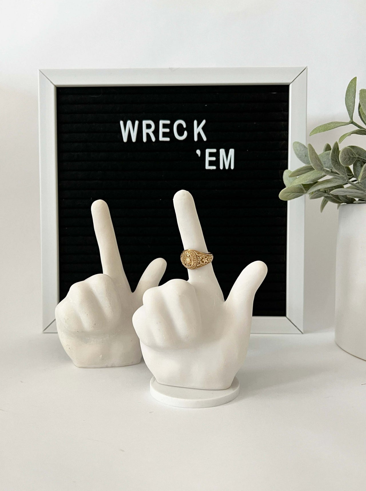 ring holder in texas tech hand sign, guns up.